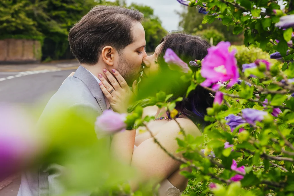 Couple kissing behind pink hibiscus