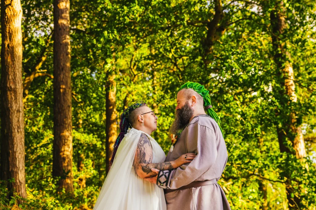 Couple with colourful hair gazing at each other in sunlit woodland