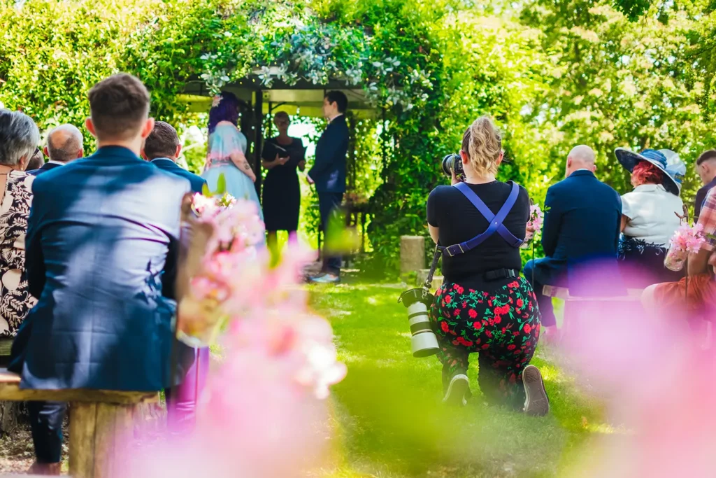 Wedding ceremony in a garden seen from behind the guests
