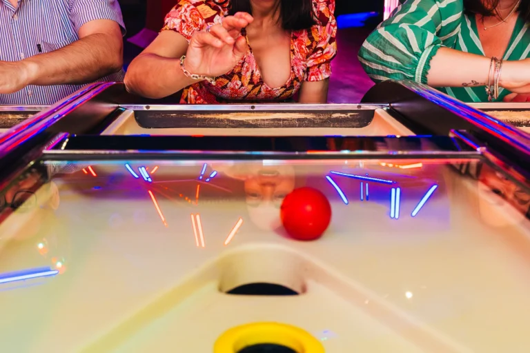 Wedding guests playing an arcade game during the reception