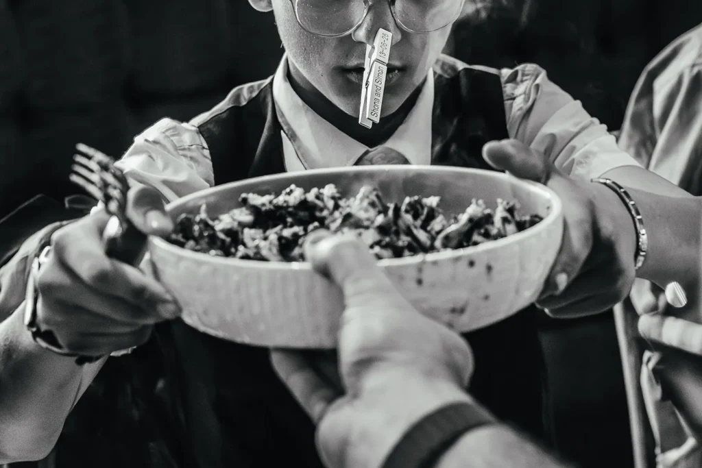 Guest with a personalised peg on their nose being offered a bowl of food