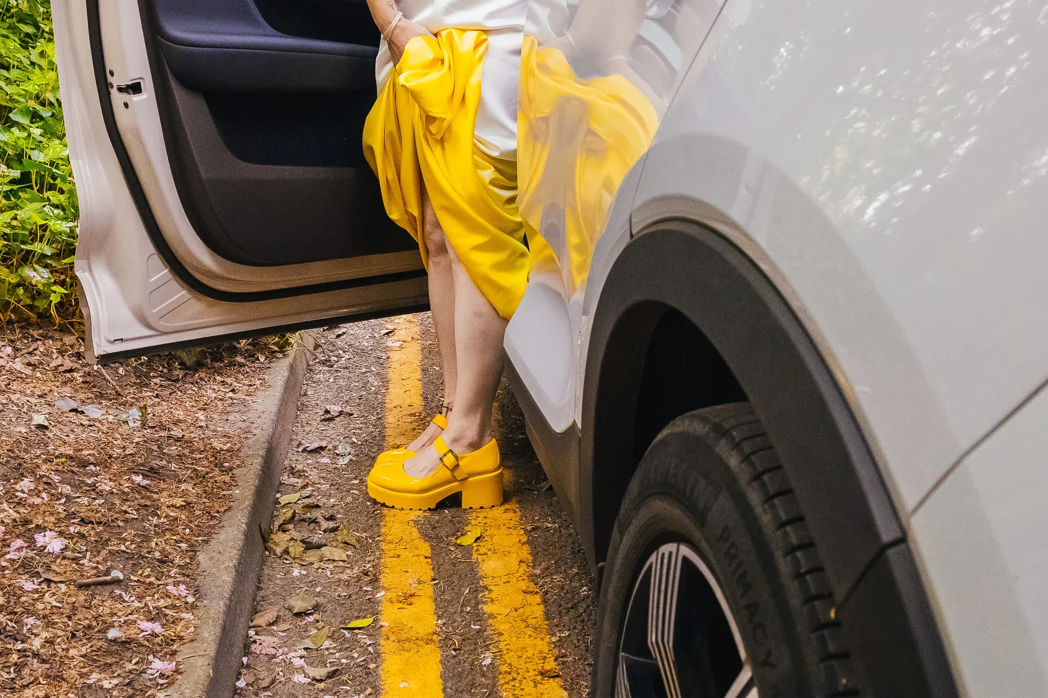 Bride stepping out of the car at Arnot Hill House in yellow shoes