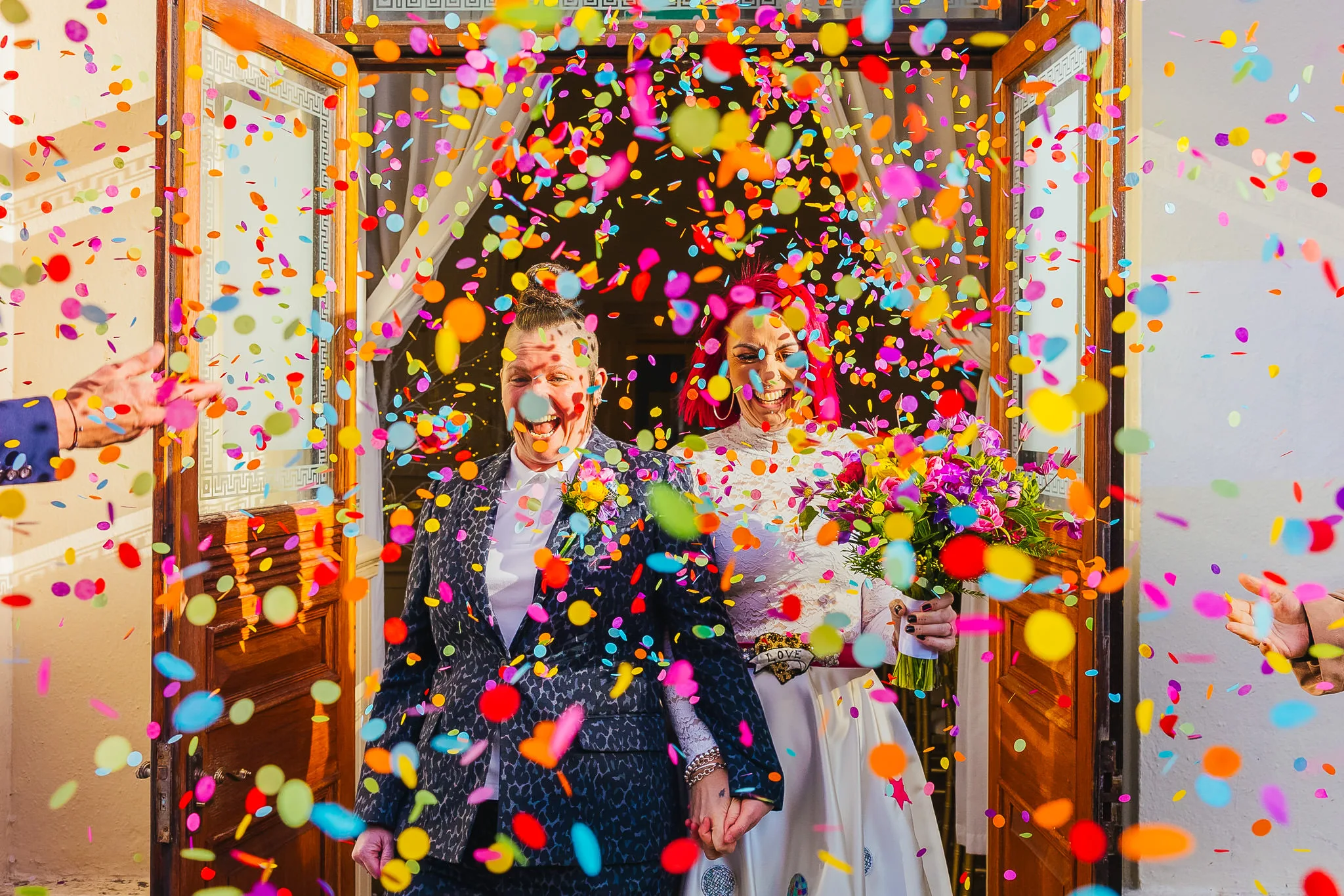 Couple walking through rainbow confetti in Brighton