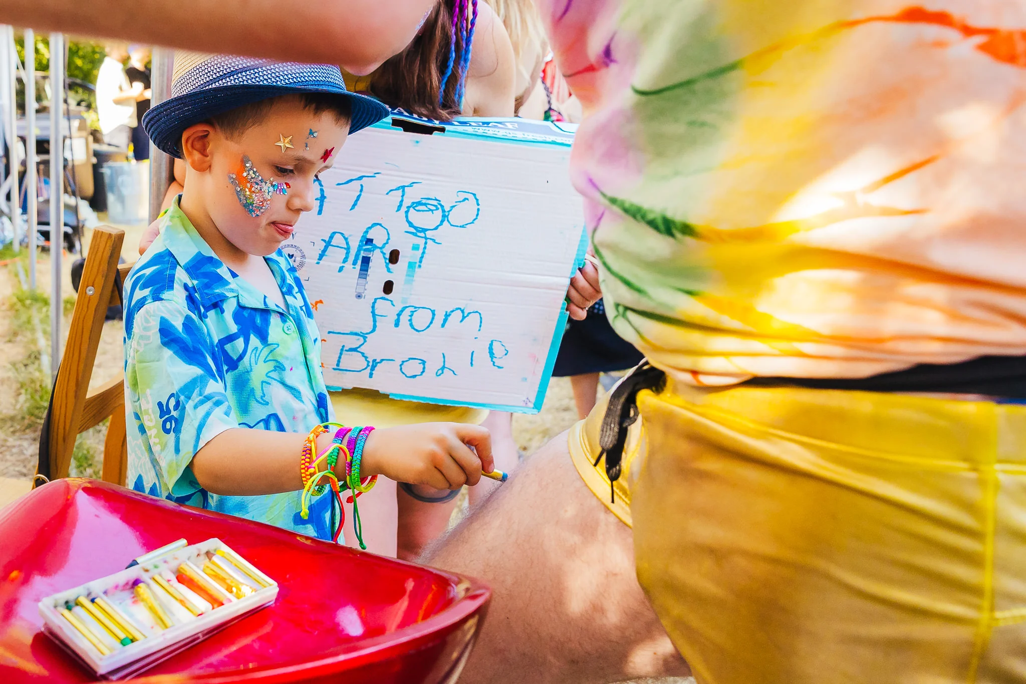 Young guest holding a handmade sign at a festival wedding