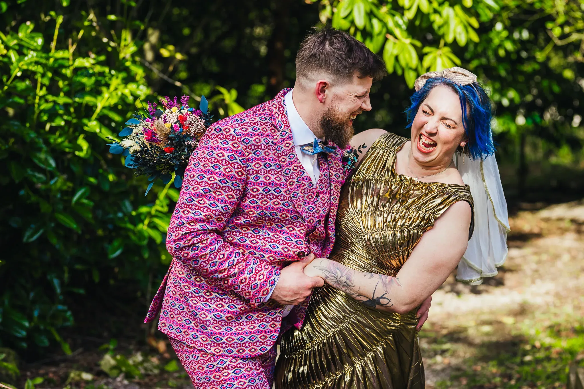 Couple laughing in colourful outfits at Hargate Hall