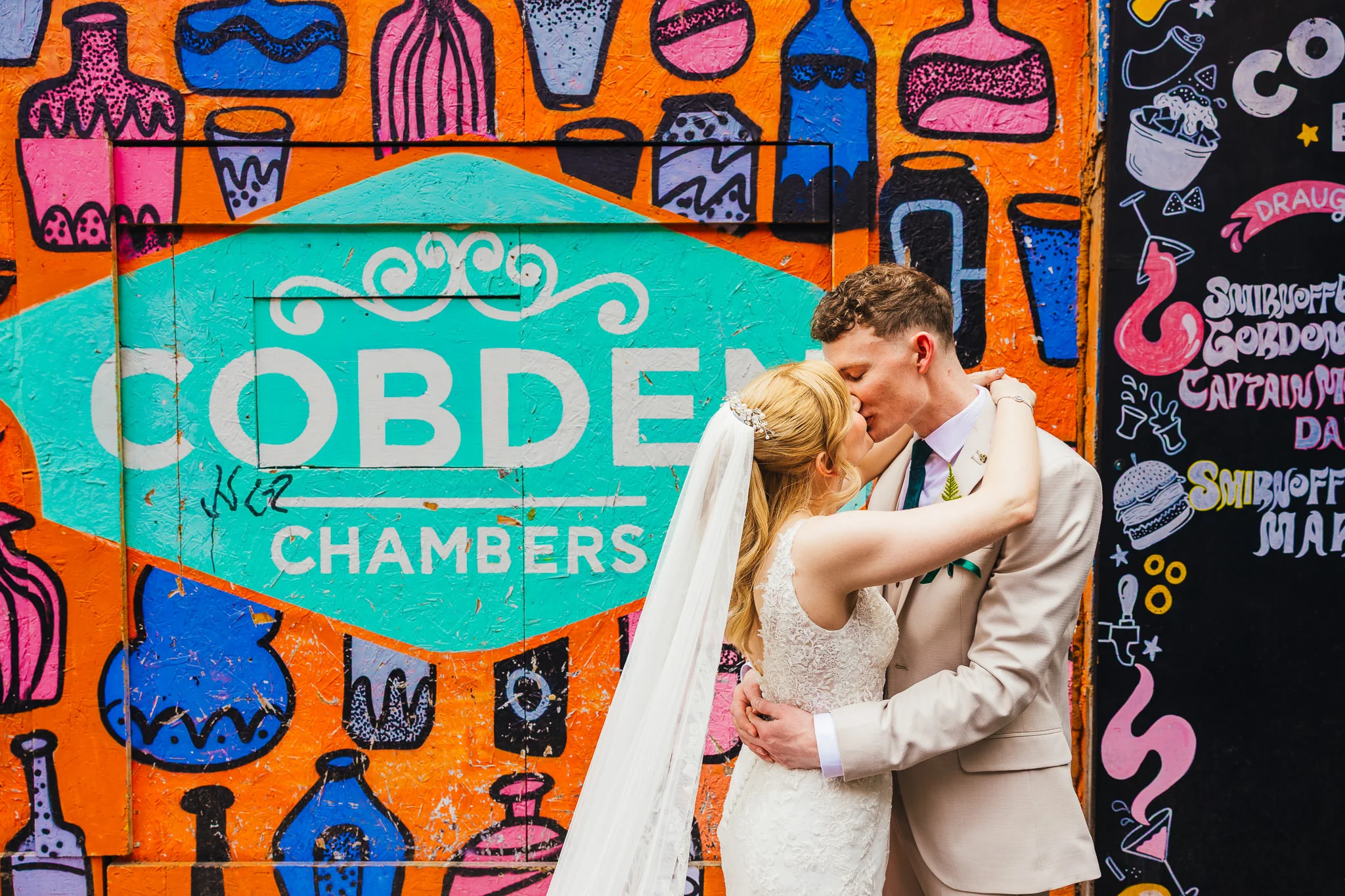 Couple kissing by the Cobden Chambers mural in Nottingham