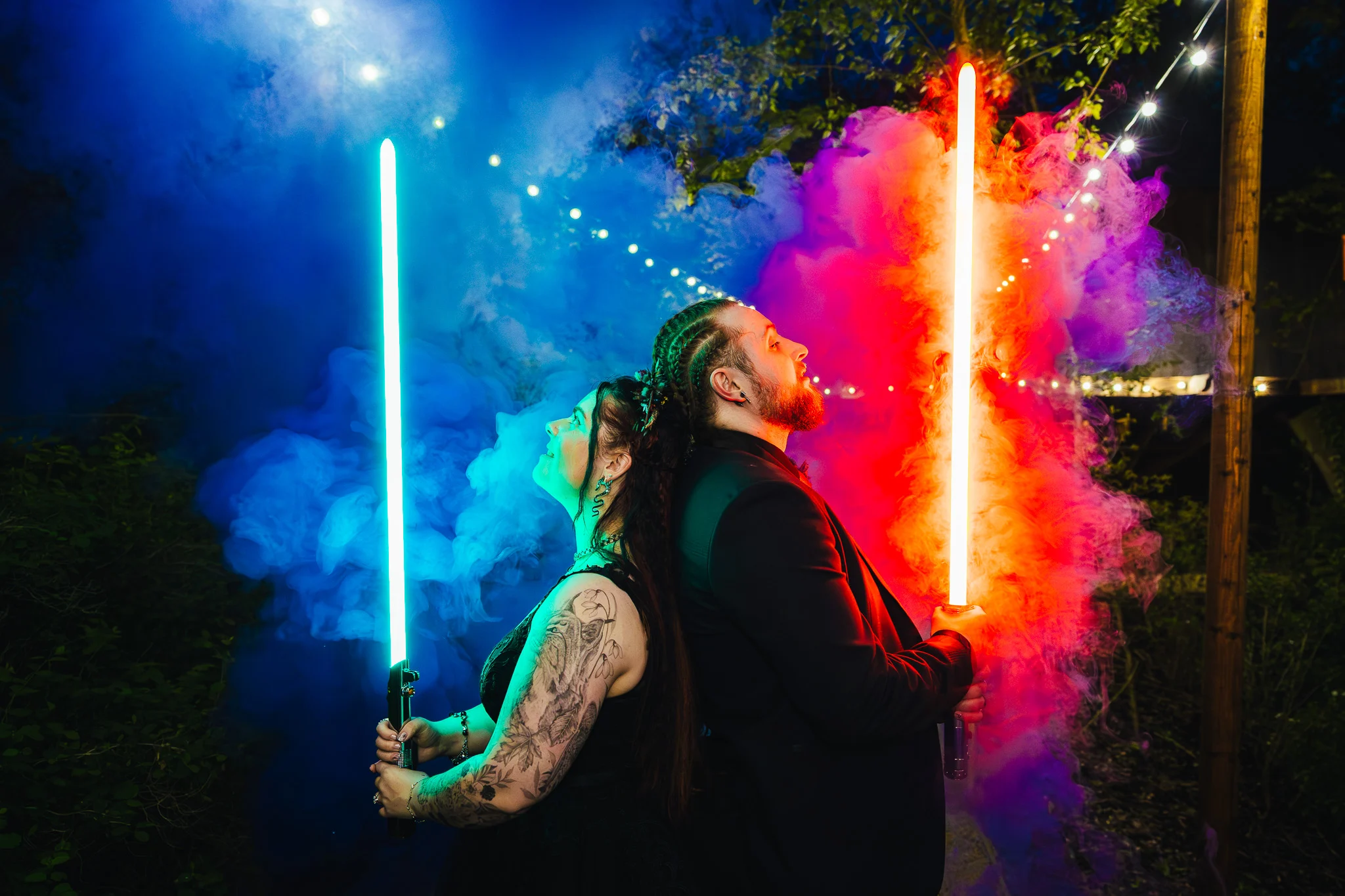 Couple back to back with lightsabers in coloured smoke